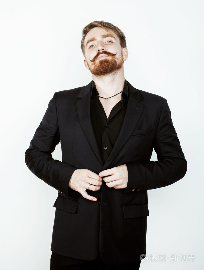 年轻的红头发男人留着胡子,胡子在白色背景上的黑色西装