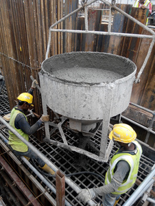 一群建筑工人浇注混凝土浆成桩帽模板