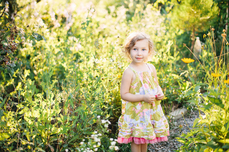 一个小女孩在花园里散步的肖像