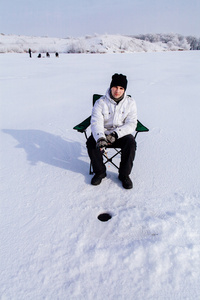 在冰冻的湖面上冬季渔夫
