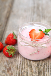 草莓酸奶和成熟草莓木制的桌子上