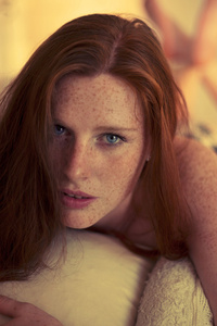 脸上有雀斑的红发在日落时的卧室里
