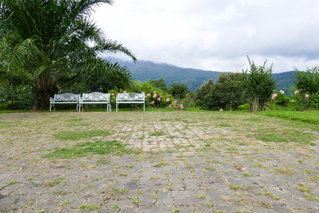 白色金属长凳在庭院与山景