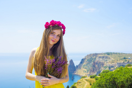 年轻美丽的白种的女性在旁的峭壁上大海充满活力黄色穿着