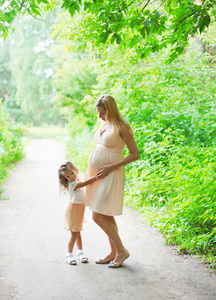 孕妇母亲和小女儿一起走路