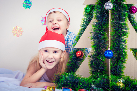 快乐小微笑男孩和女孩戴着圣诞帽子