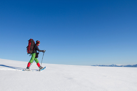 在山里徒步旅行带着背包和帐篷雪的冬天