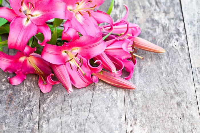 粉红色的百合罗比娜鲜花花束仿古木制的桌子上