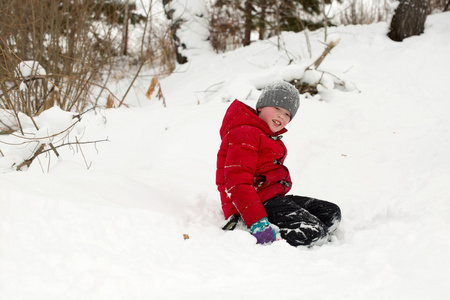 快乐的男孩在外面的雪堆里玩冬天