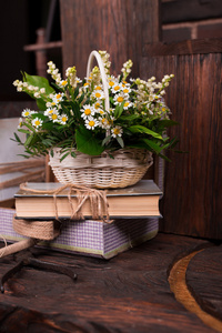 洋甘菊装饰组成与书和褐色的木桌上的盒子
