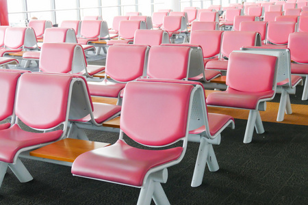 在机场的粉红色真皮椅子的行