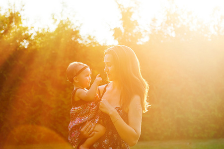 母亲和可爱的女儿，在阳光明媚的公园