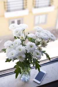 在窗台上的花瓶里的新鲜菊花