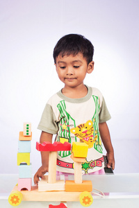 一个小的亚洲男孩玩玩具块木