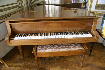 老式的钢琴和钢琴凳