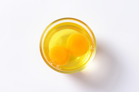 鸡蛋的蛋清和蛋黄放在玻璃碗图片