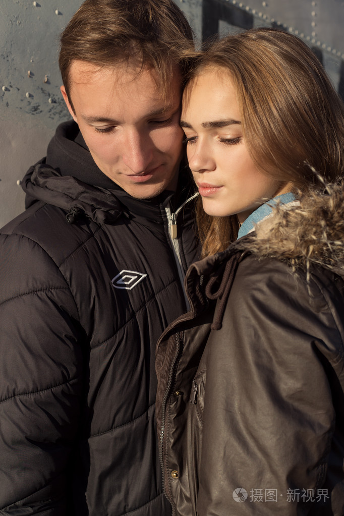 拥抱爱美丽幸福可爱夫妻和壁附近日落时闭着眼睛落在一个温暖的晚上