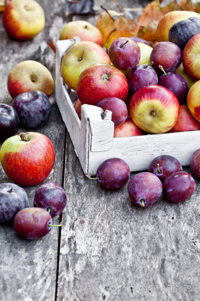 时令水果苹果和李子木制的桌子上