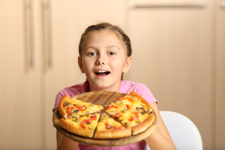 小女孩在家里吃披萨