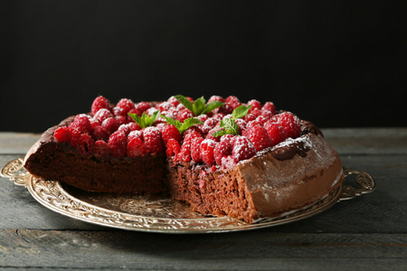 蛋糕巧克力釉与覆盆子对深色背景上的纸盒