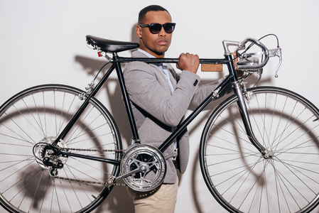 戴墨镜的非洲男人骑自行车
