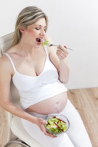 孕妇吃蔬菜沙拉的肖像
