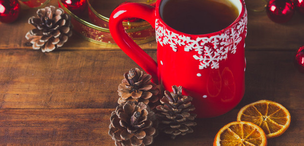 红杯茶和圣诞球木制背景