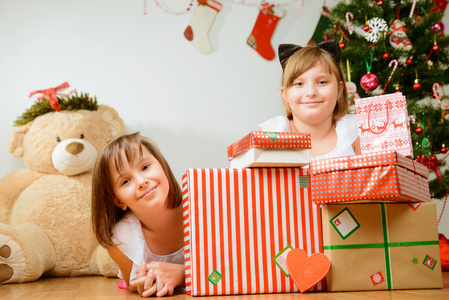 两个女孩在与礼物的圣诞树前