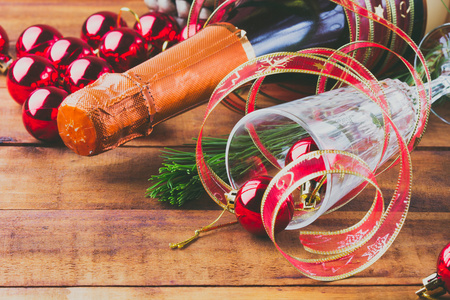 新的一年或圣诞节组成。瓶起泡酒 酒杯和圣诞球木制背景