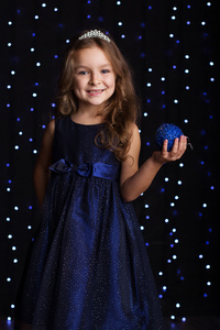 漂亮的女孩拿着蓝色的圣诞球