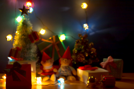 在幸福之夜, 圣诞之光变得模糊和模糊。圣诞快乐装饰装饰与可爱的熊, 礼物, 圣诞树, 和丝带是圣诞装饰品