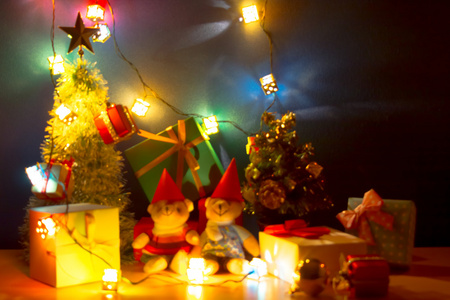 在幸福之夜, 圣诞之光变得模糊和模糊。圣诞快乐装饰装饰与可爱的熊, 礼物, 圣诞树, 和丝带是圣诞装饰品