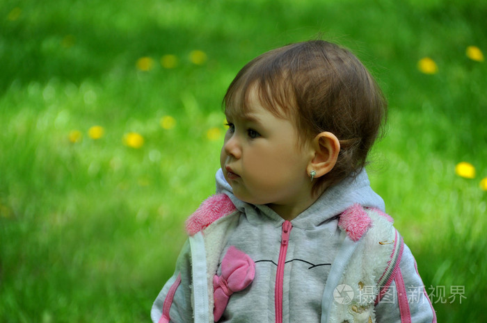 一个年轻女孩的绿草背景上的肖像