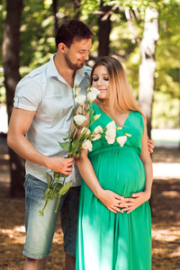 幸福的夫妇   丈夫和他怀孕的妻子在秋天的公园