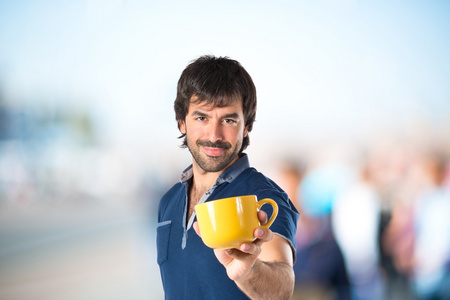 男子捧着一杯咖啡，在白色的背景