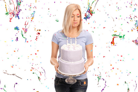 悲伤的女人抱着一个生日蛋糕