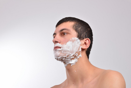 一个年轻人准备刮胡子的特写，泡沫又放他 c