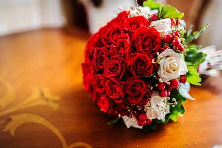 木制的桌子上的红色婚礼花束