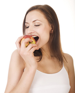 年轻漂亮的黑发女孩吃红苹果，与白色隔离
