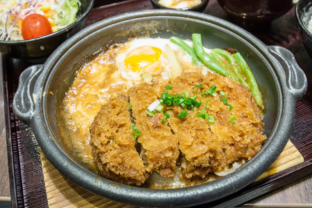 深发射用鲜鸡蛋顶部上碗米饭煮熟的猪肉。基本的日本食品