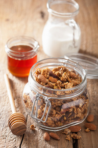 自制健康格兰诺拉麦片在玻璃罐和蜂蜜