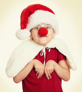 在圣诞老人的帽子小丑鼻子上白色隔离的女孩