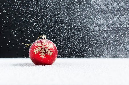 圣诞球在雪地上，飘落的雪花