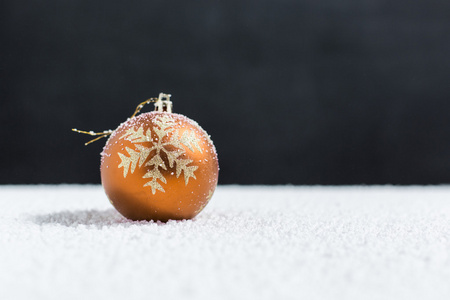 圣诞球在雪地上，飘落的雪花