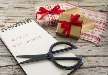 圣诞礼物 笔记本 剪刀和红丝带上木制黑色