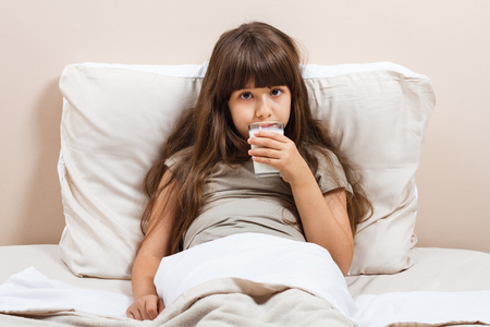 睡前喝牛奶女孩在床上喝牛奶照片