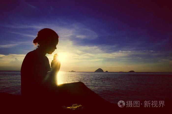 年轻女子在日落祷告