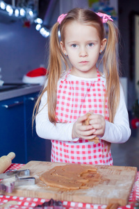 小可爱的女孩在家用厨房烤圣诞姜饼