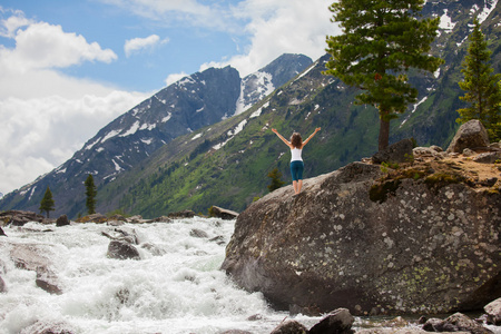 年轻女子正在练习瑜伽在山区河流