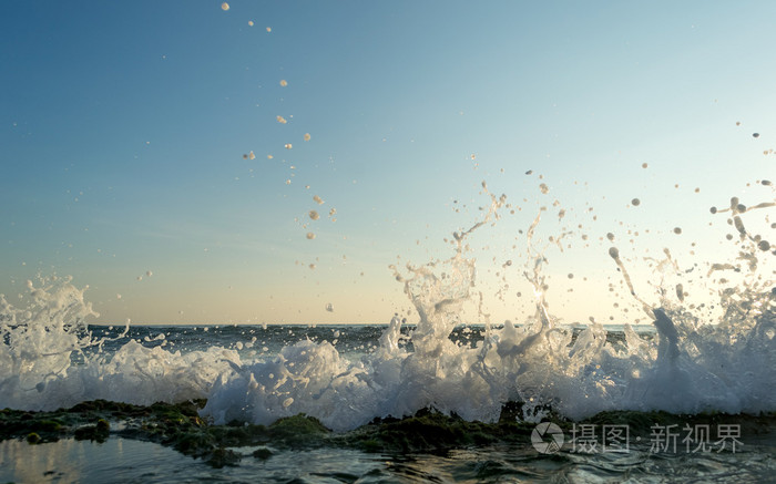波浪拍打多石的海滩，形成喷雾剂